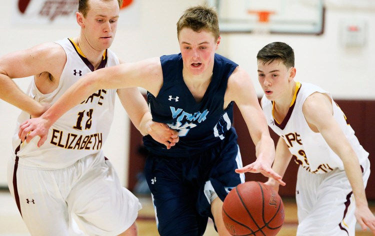 York senior Trevor LaBonte runs the ball through Cape Elizabeth's Quinn Hewitt (12) and Jacob Allen during Monday night's game at Cape Elizabeth. Labonte had 23 points and 15 rebounds in the game.