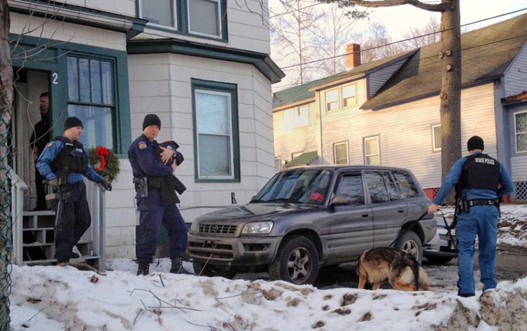 After a standoff with an armed man ended, Waterville police and Maine State Police remove a 20-day-old infant from 2 Front Place on Saturday in Waterville. 