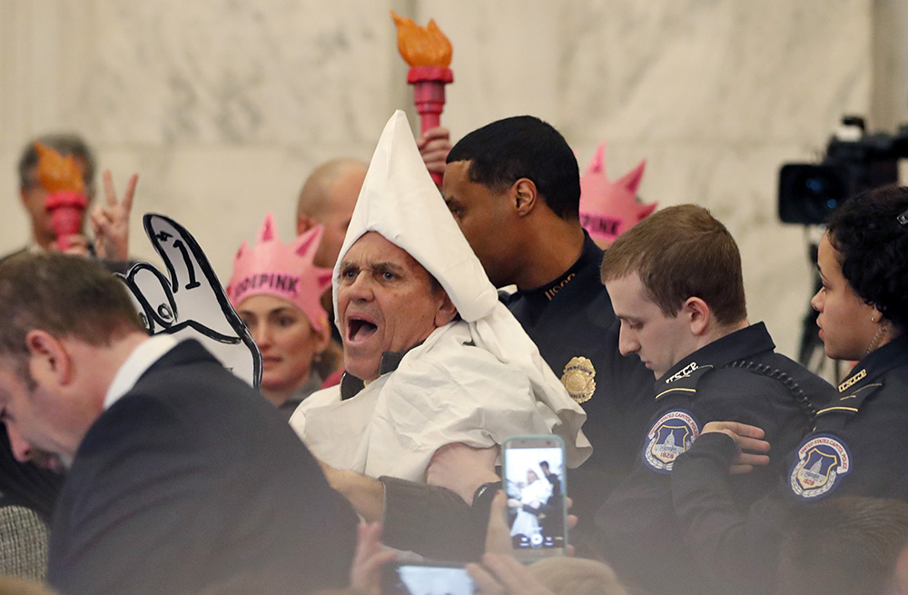 A protester is escorted out of the Senate Judiciary Committee's confirmation hearing Tuesday for Attorney General-designate Sen. Jeff Sessions. <em>Associated Press/Alex Brandon</em>