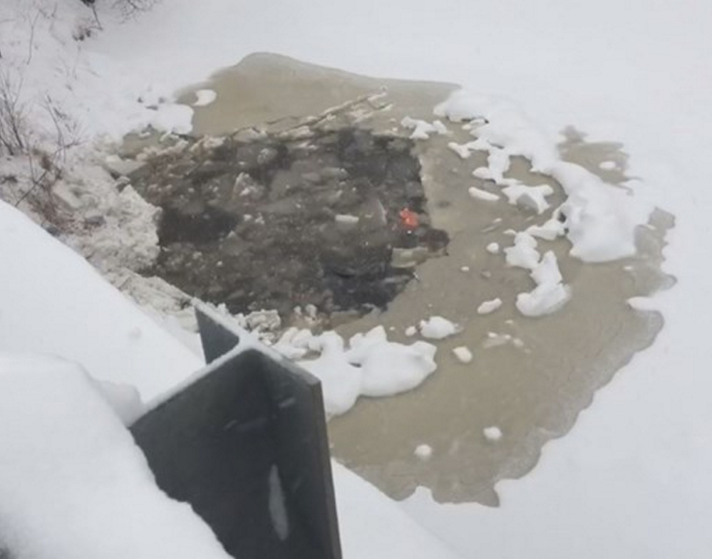 An SUV made this hole in the ice on Swan Pond after it went off the South Street bridge in Biddeford on Thursday morning.