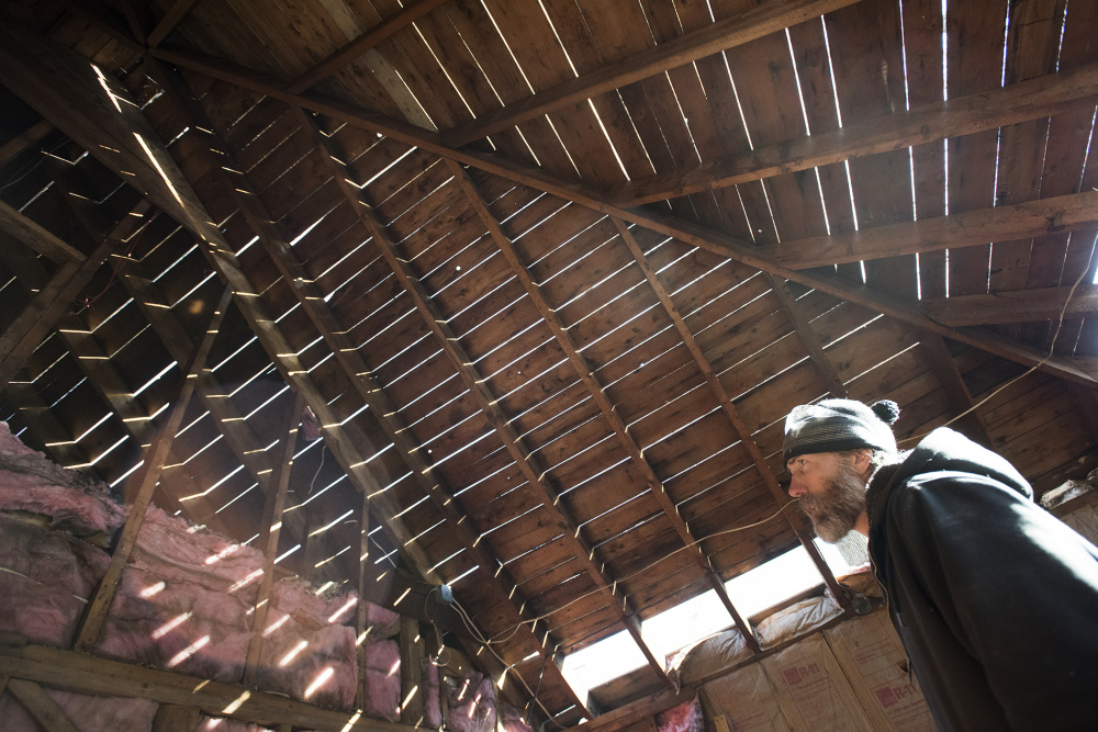 Brett Trefethen of Barn Boards and More last week inspects a second floor room, where wood is being reclaimed by his company at 18 Dennis St. in Gardiner, the former estate of Frank E. Boston.