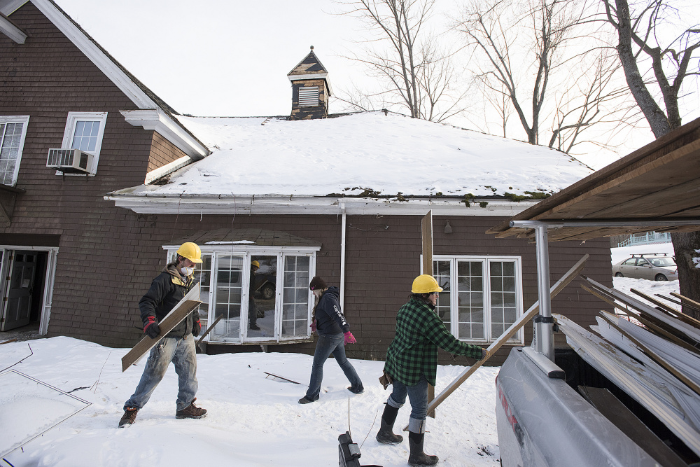 Workers employed by Barn Boards and More salvage wood molding and boards last week from 18 Dennis St. in Gardiner, the former estate of Frank E. Boston.