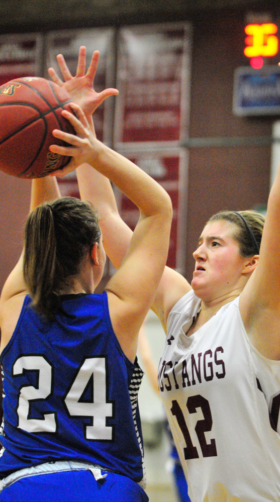 Kaylee Knowles of Searsport, left, looks to pass while guarded by Abbey Allen of Monmouth Academy during Monmouth's win in a Class C South prelim Tuesday.