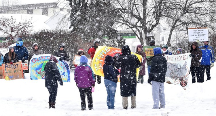 Several protesters stand in front of a TD Bank branch Saturday on Main Street in Waterville, advocating for the bank's divestment from the Dakota Access Pipeline project. The gathering was a response to President Donald Trump's executive order that encourages the construction of the pipeline.