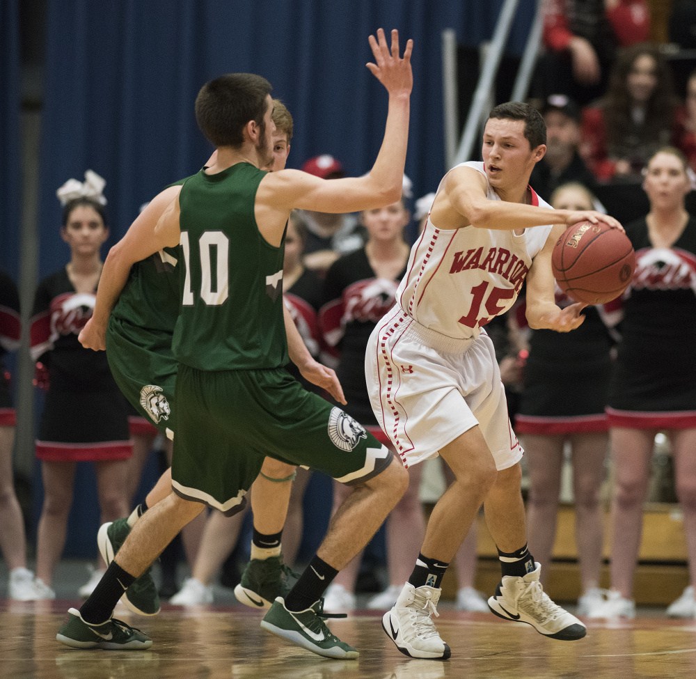 MARCH 3: Wells' Owen Berry looks for an open man as MDI's Andrew Phelps applies presure during the Class B boys' basketball state championship game at the Augusta Civic Center. MDI won the title, 59-39.
