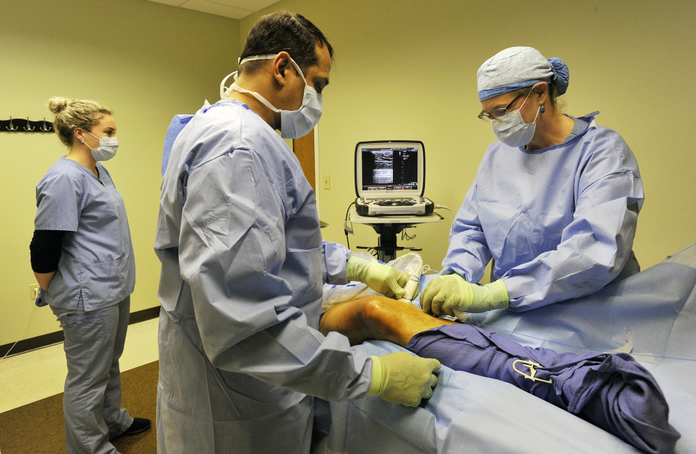 SOUTH PORTLAND, ME - FEBRUARY 28: Dr. Cindy Asbjornsen, right, performs a laser procedure on a patient at Vein Healthcare Center in South Portland Tuesday, February 28, 2017. She is assisted by Sam Armfield a registered vascular ultrasound technologist, center, and medical assistant Michaela Fortin, left. (Staff photo by Shawn Patrick Ouellette/Staff Photographer)