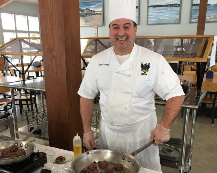 Hyde School chef Michael Flynn prepares samples of the vegan Crispy Blueberry Burger in the boarding school's dining hall.