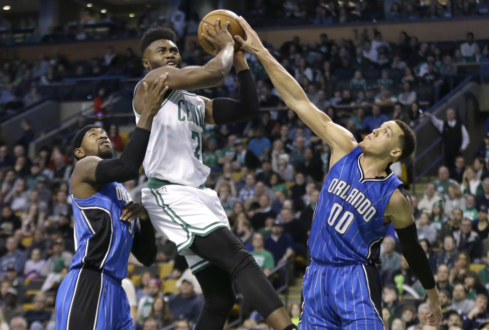 Boston's Jaylen Brown drives to the basket against Orlando forwards Terrence Ross, left, and Aaron Gordon in the first quarter Friday night in Boston.