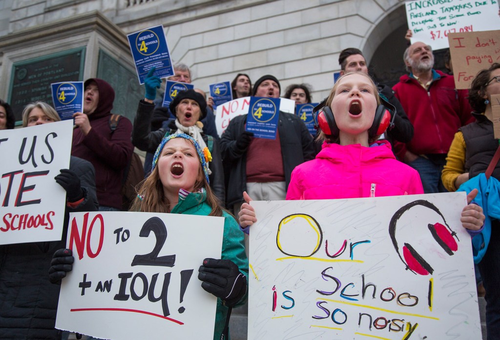 Isabella Figdor, 9, left, and Nina Schafer, 8, students at Reiche Elementary School, join in Tuesday's rally at City Hall.