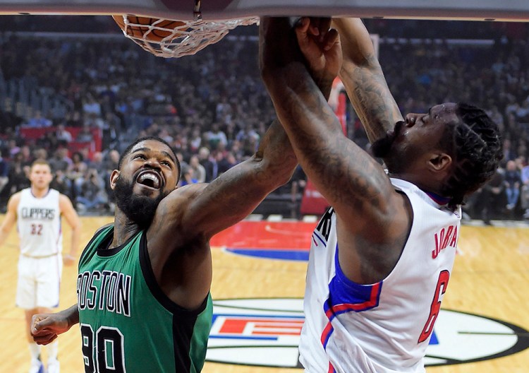 Clippers center DeAndre Jordan, right, dunks as Celtics forward Amir Johnson defends during the first half of Monday, night's game in Los Angeles. 