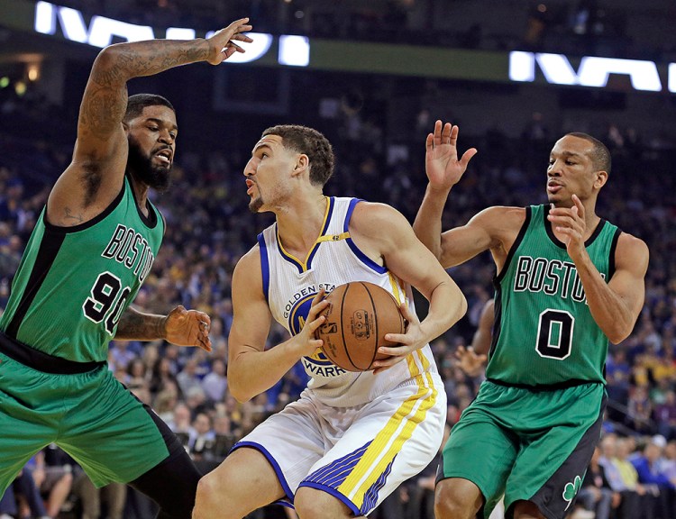 The Celtics' Amir Johnson, left, and Avery Bradley guard the Warriors' Klay Thompson in the first half of  Wednesday night's game  in Oakland, Calif. "They did a good job of guarding the 3," Thompson said after the game. "Teams know we can kill them from 3."