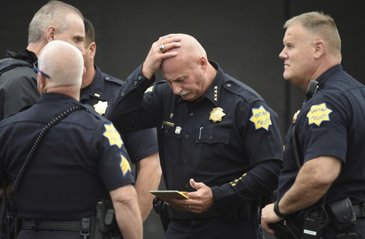 Fresno Police Chief Jerry Dyer reviews notes about the triple fatal shooting before addressing the media Tuesday in Fresno, Calif. 