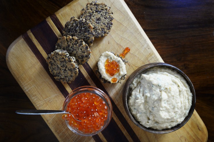 Sunflower-Flax Seed Frico with Navy Bean-Rosemary Hummus and fish eggs.