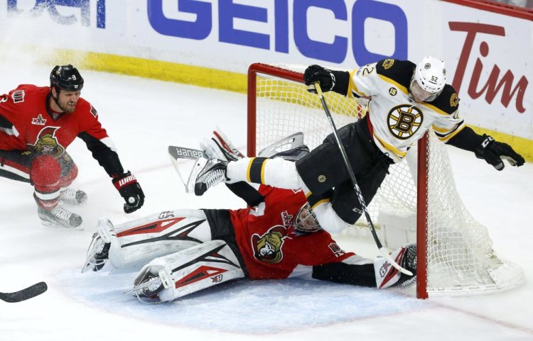 Boston's Sean Kuraly flies over Ottawa goalie Craig Anderson as Senators defenseman Marc Methot watches in the first overtime of Game 5 Friday in Ottawa, Ontario.