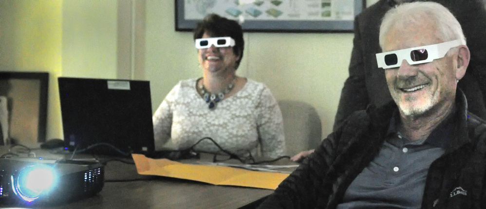 Jennifer Dube of Friends of the Maine State Museum and sportsman Paul Wade try out glasses for watching stereoview photos showing Maine's hunting, trapping and fishing history. There will be a presentation of the photos Saturday at the Elks Lodge in Augusta.