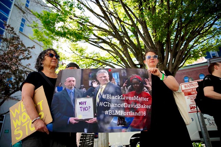 Activists Naomi Mayer, left, and Carolyn Barschow were among about 20 protesters outside Cumberland County Courthouse in Portland Friday morning.