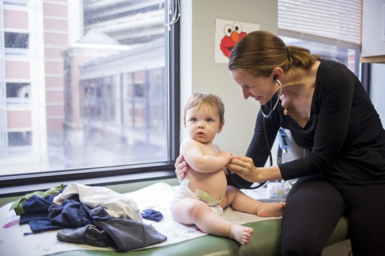  Dr.Ann Coates, a pediatric pulmonologist, listens to Reid Shores' breathing during his appointment, which happened to fall on his first birthday.