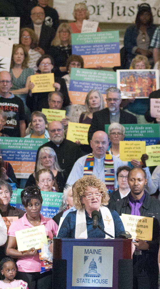 Rev. Carie Johnsen of the Unitarian Universalist Community Church speaks Wednesday in the Hall of Flags at a rally to promote programs for immigrants.religious leaders in the State House Hall of Flags in Augusta.