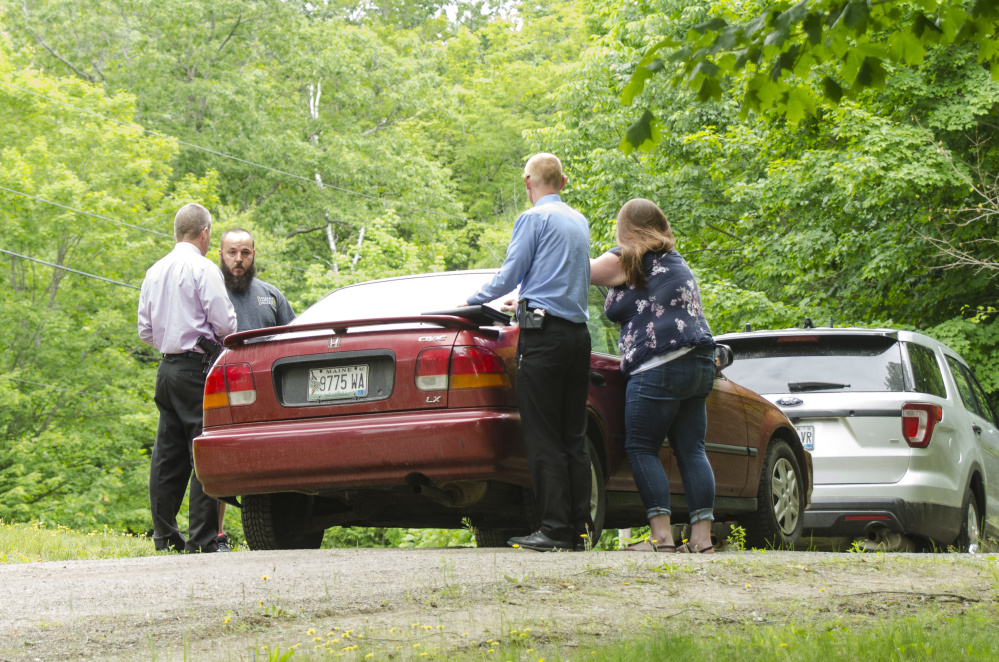 Detective Benjamin Sweeney, left, and Sgt. Christopher Tremblay, both of the Maine State Police, confer on Saturday at the scene of a fatal shooting off Yeaton Drive in West Gardiner, The victim, James Haskell, 41, was a visitor at the property, according to Steve McCausland, spokesman for the Maine Department of Public Safety.