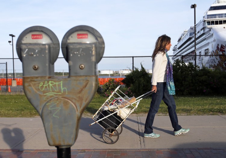 Lisa Twombly of Peaks Island carts her belongings toward the ferry terminal. There are 55 waterfront spaces designated for islanders and there's heavy competition for those spots.