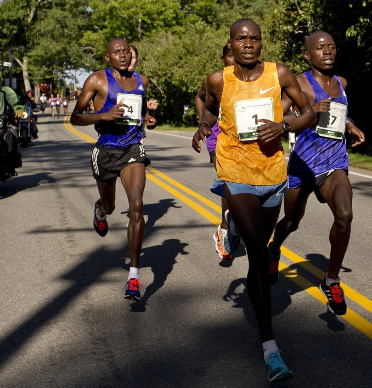 Stephen Koskei Kibet of Kenya, in yellow, leads the pack on his way to a victory after two runner-up finishes.