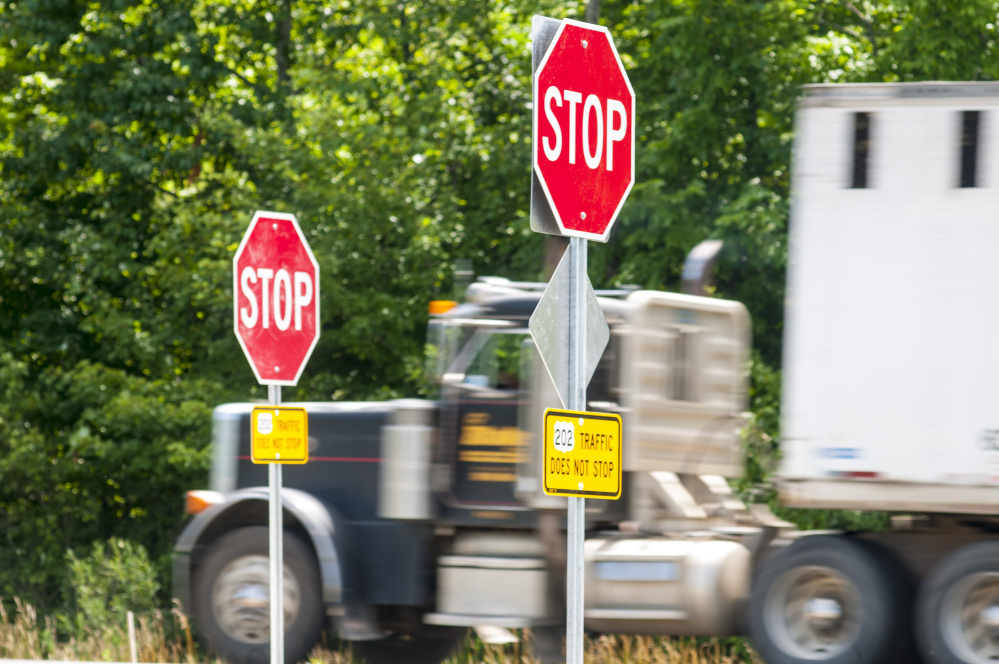 A tractor-trailer on U.S. Route 202 zooms past stop signs at Main Street intersection on Friday in Winthrop.