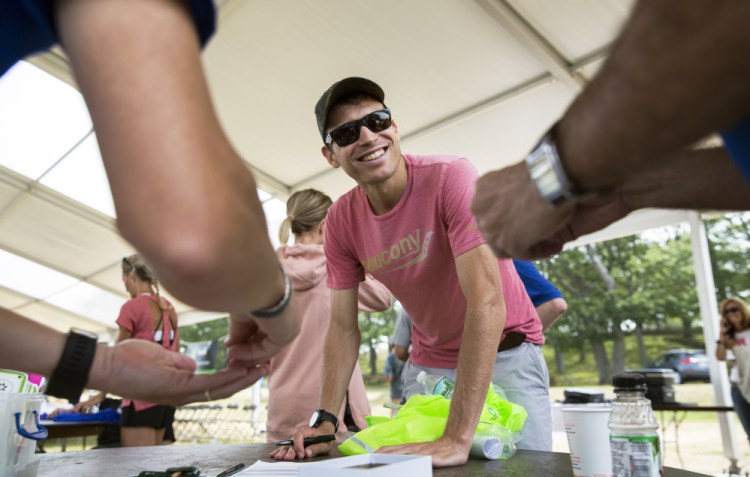 Ben True, the North Yarmouth native who became the first American to win the Beach to Beacon 10K last year, receives his bib along with the other elite runners Friday at Fort Williams in Cape Elizabeth. The 20th annual race will be run Saturday.