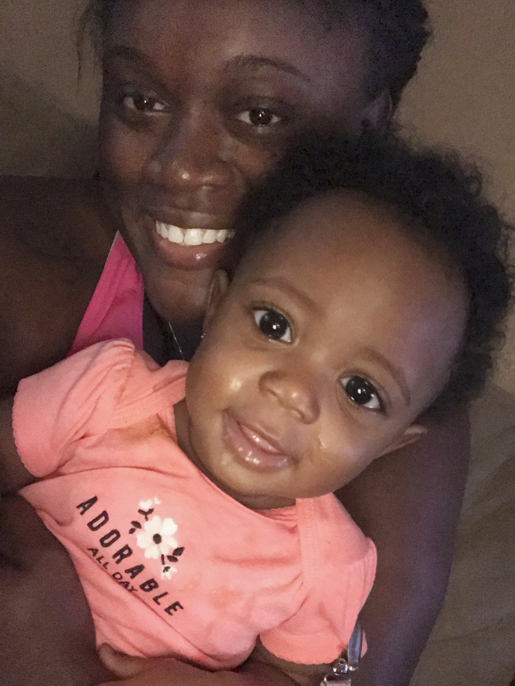 Bajauh Henix takes a photo Monday with her daughter Paige Booth after being reunited nearly four hours after the two evacuated from their home in Houston. Bajauh Henix and her mother, Kennesha Grand, were evacuating through high water and rain when they handed the baby off to a police officer on a personal watercraft. But when Grand and Henix reached the area where the child was supposed to be, no one there knew her whereabouts.