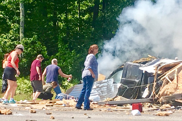 Passers-by converge to lend a hand moments after the crash on the Maine Turnpike near Exit 36 in Saco on Aug. 4.