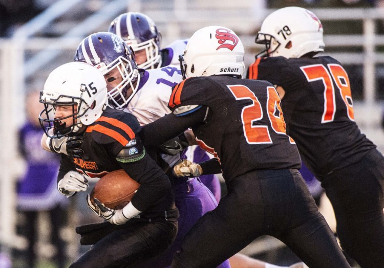 Skowhegan running back Hunter Washburn gets wrapped up by Marshwood senior Joseph Taran in Friday night's game at Clark Field in Skowhegan.