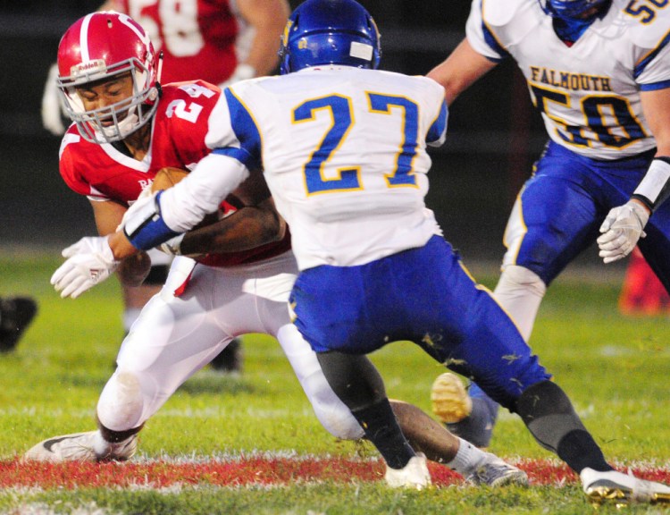 Cony wide receiver Jordan Roddy, left, gets tackled by Falmouth cornerback Garret Aube during the game Friday in Augusta. Roddy finished with seven catches for 91 yards with a touchdown, but Falmouth won, 41-19.