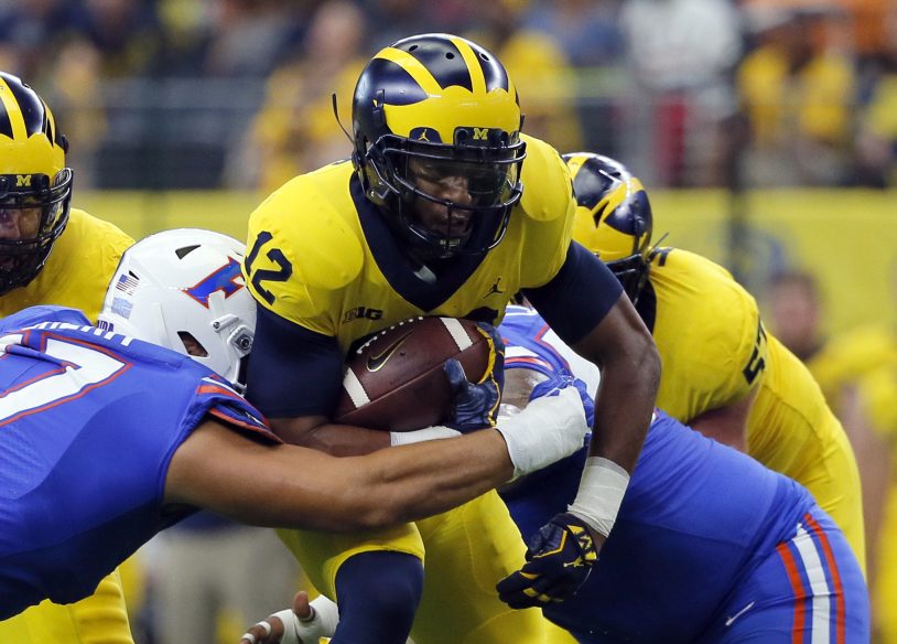 Florida defensive lineman Jordan Sherit, left, attempts to stop Michigan running back Chris Evans with help from teammates during their season opener Saturday in Arlington, Texas. No. 11 Michigan beat No. 17 Florida, 33-17.