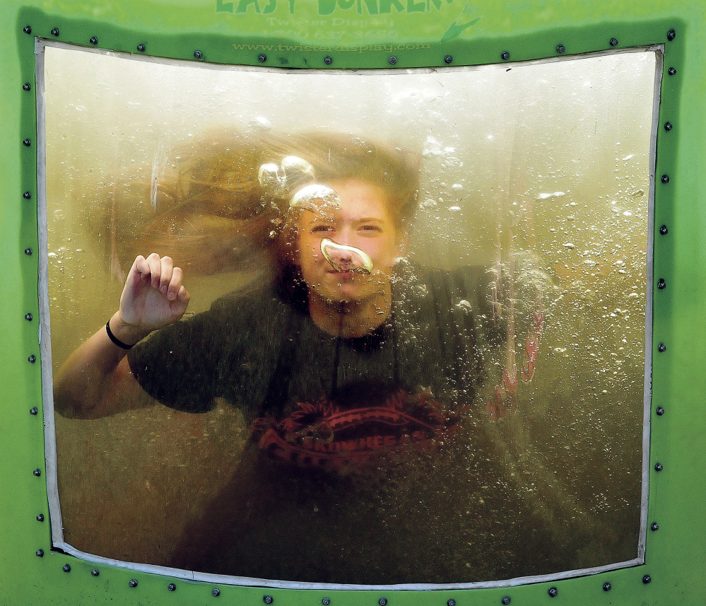 Skowhegan Area High School cheerleader Bailey Wilson takes a plunge in a dunk tank during a fundraiser for the cheerleading and field hockey teams.