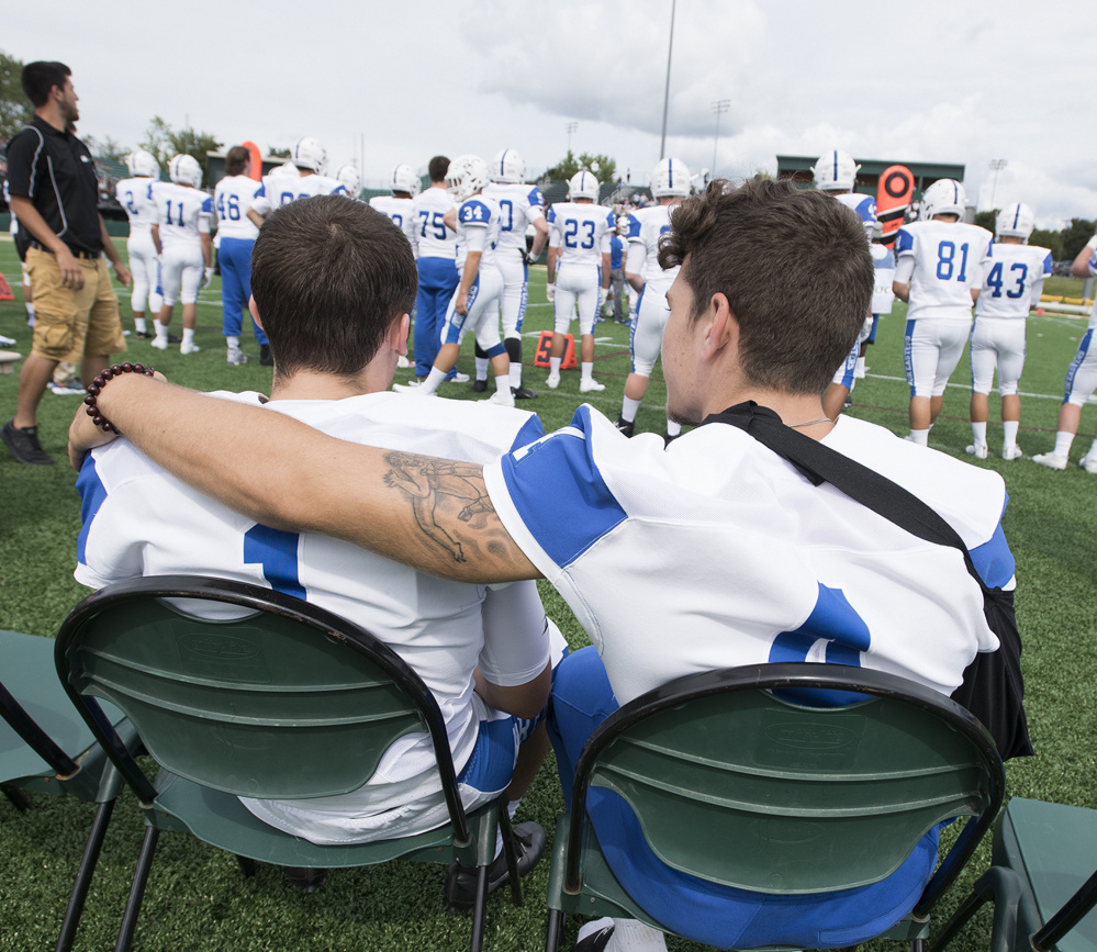 Defensive back Joey Curit, left, of Biddeford shares a moment with linebacker Michael Tuzzo during Sunday's game. Curit and Tuzzo are among the 55 freshman on UNE's roster.