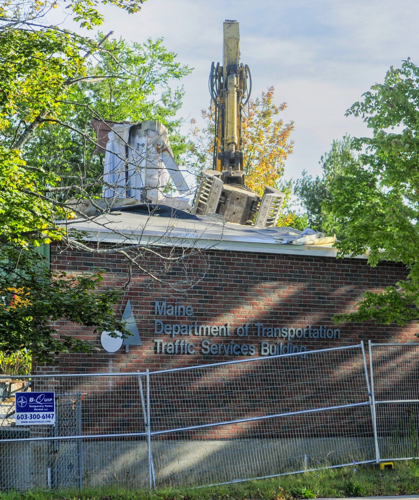 An excavator rips apart the old state DOT building on Sewall Street in Augusta on Friday to make way for a new building to house Maine Public Employees Retirement System offices.
