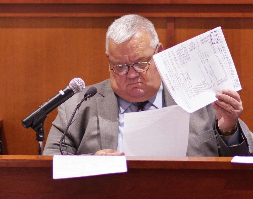 Retired Portland Police detective Daniel Young looks over an investigative report while being questioned by attorney Amy Fairfield last week. Young was one of the two detectives assigned to investigate the murder.