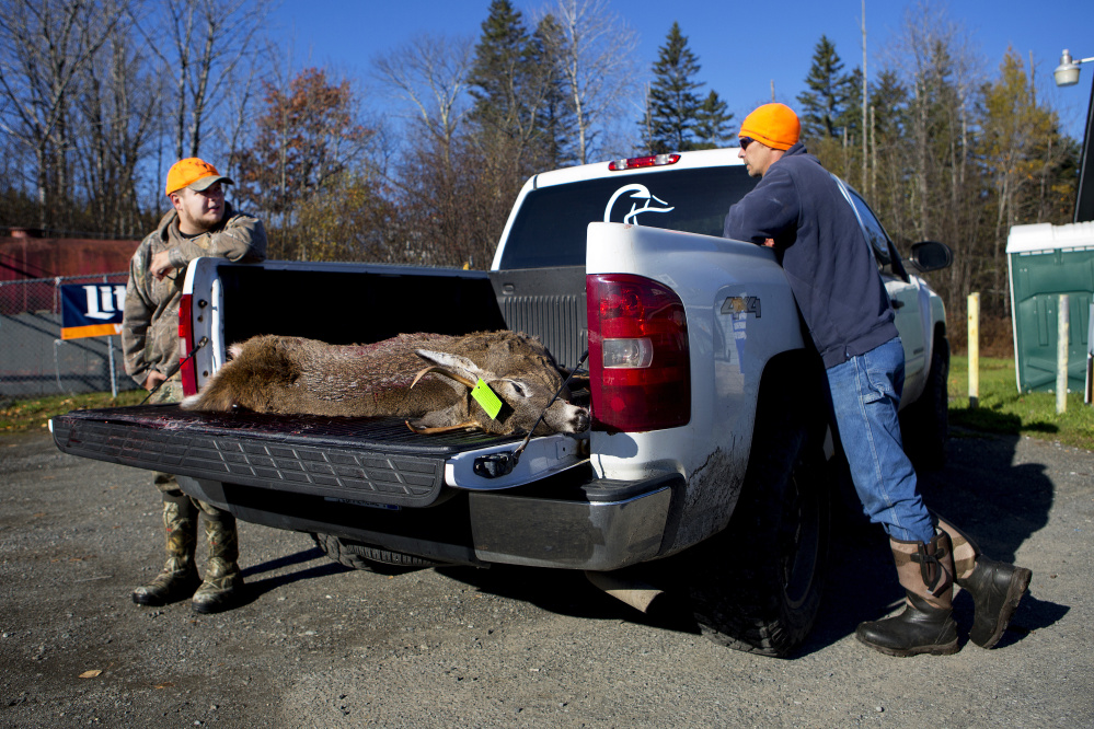 Kevin Wilkes, left, and Chris Withee wait for the deer that Tia Withee shot to be tagged Saturday at Jim's Variety in Athens.