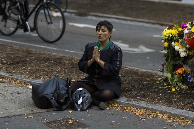 A woman sits Thursday next to a makeshift memorial for victims of Tuesday's terror attack on a bike path that left eight people dead.