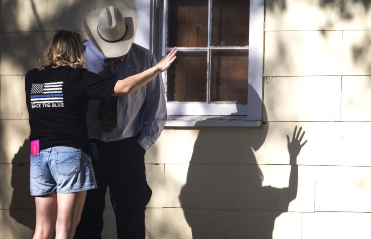 A woman prays with a man after a fatal shooting at the First Baptist Church in Sutherland Springs, Texas, on Sunday.