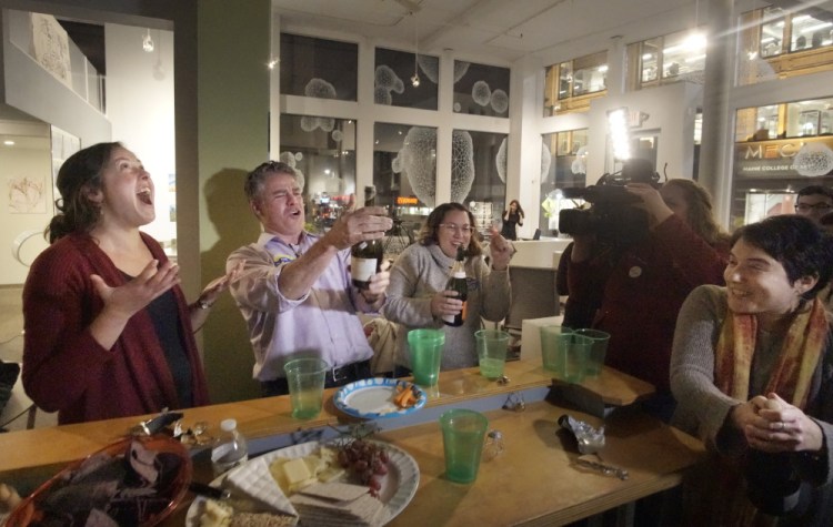 Portland Mayor Ethan Strimling pops the cork off a bottle of champagne while celebrating Tuesday at Think Tank with supporters of the Protect Our Neighborhood Schools campaign, which asked voters to support the renovation of four schools. At left is Emily Figdor, director of Protect Our Neighborhood Schools.