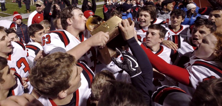 Evan Leach kisses the Class D state championship trophy after Wells defeated Foxcroft Academy 48-0 on Saturday afternoon at Fitzpatrick Stadium, completing a 12-0 season.