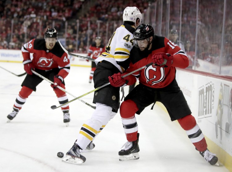Bruins defenseman Rob O'Gara and New Jersey's Drew Stafford battle for the puck near the boards in the second period Wednesday night.