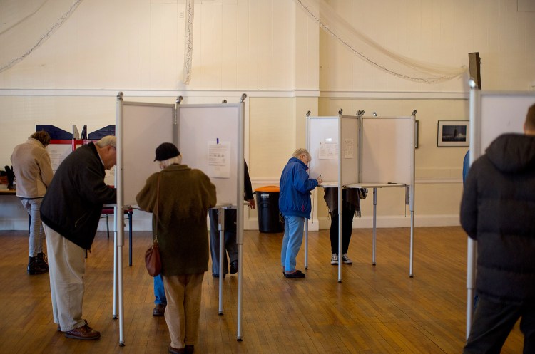 Voters fill out their ballots Tuesday at the Woodfords Club polling place in Portland's District 3. Voters in the off-peninsula district rejected the zoning and rent proposals on the city ballot by wide margins.