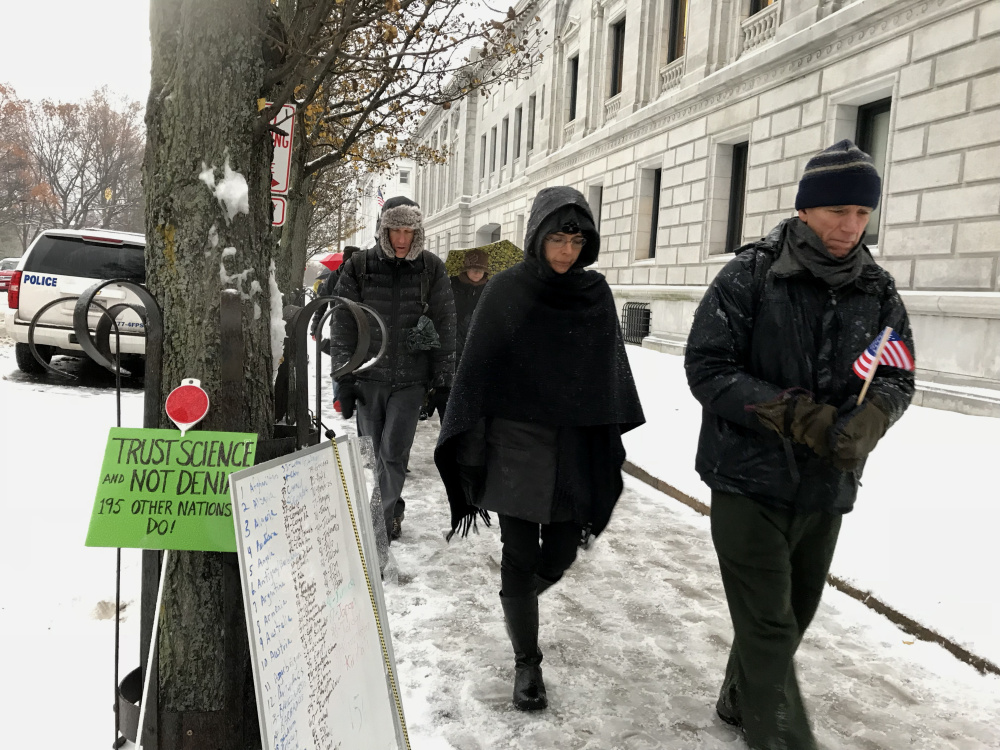 Quaker community members and others held a walking vigil in Portland on Tuesday "as an act of grief" over President Trump's plans to withdraw from the Paris accord. accord on Tuesday with a "walking vigil" around the federal courthouse in Portland.