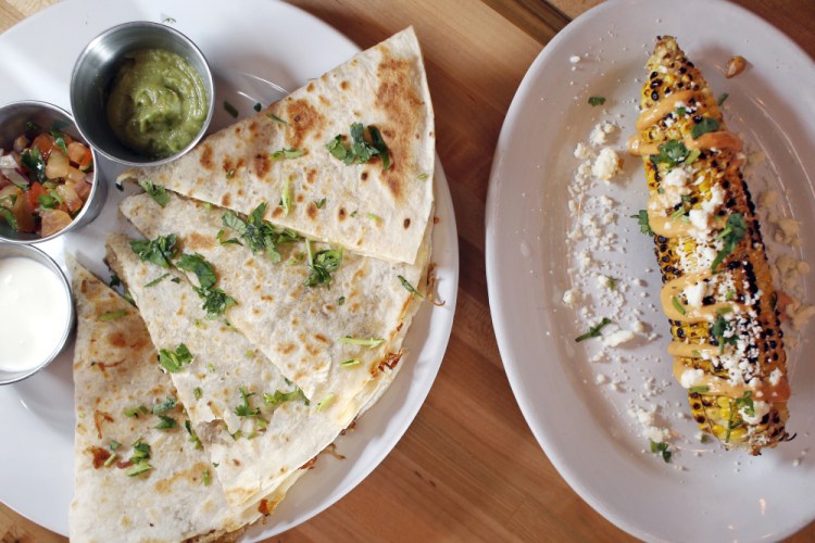 Carnitas quesadillas, left, with guacamole, Mexican crema and pico de gallo; and grilled Mexican-style corn on the cob with chipotle aioli, cotija cheese and cilantro.