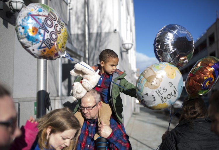 Rich Maynard, 40, holds Alden, 3, outside District Court in Portland. Rich and his wife, Napthali, below with Alden, became adoptive parents Wednesday. Alden, named for country singer Jason Aldean, is the latest addition to a family that includes two other foster kids.