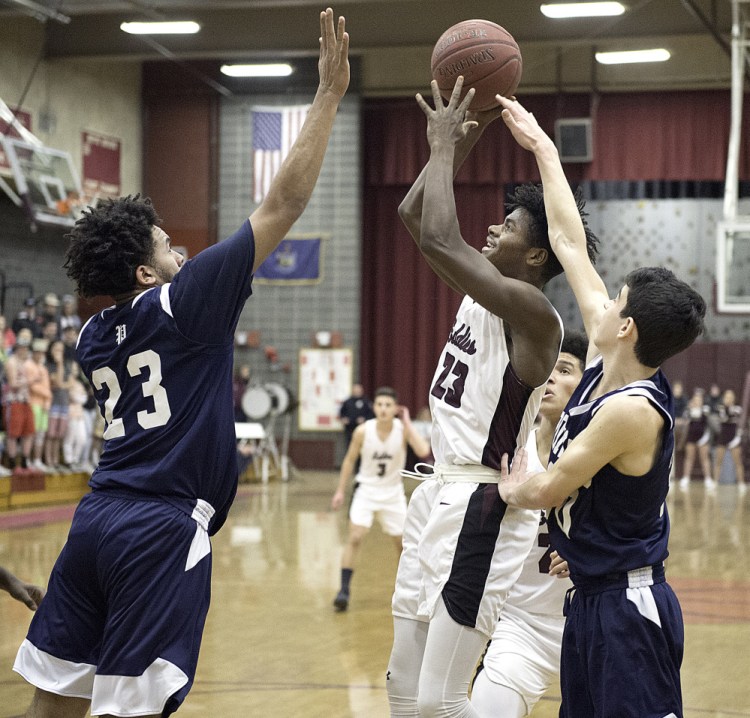 Ibn Khalid of Edward Little shoots over Portland's Trey Ballew during a Class AA North basketball game Friday night in Auburn. Portland remained undefeated with a 78-70 win.