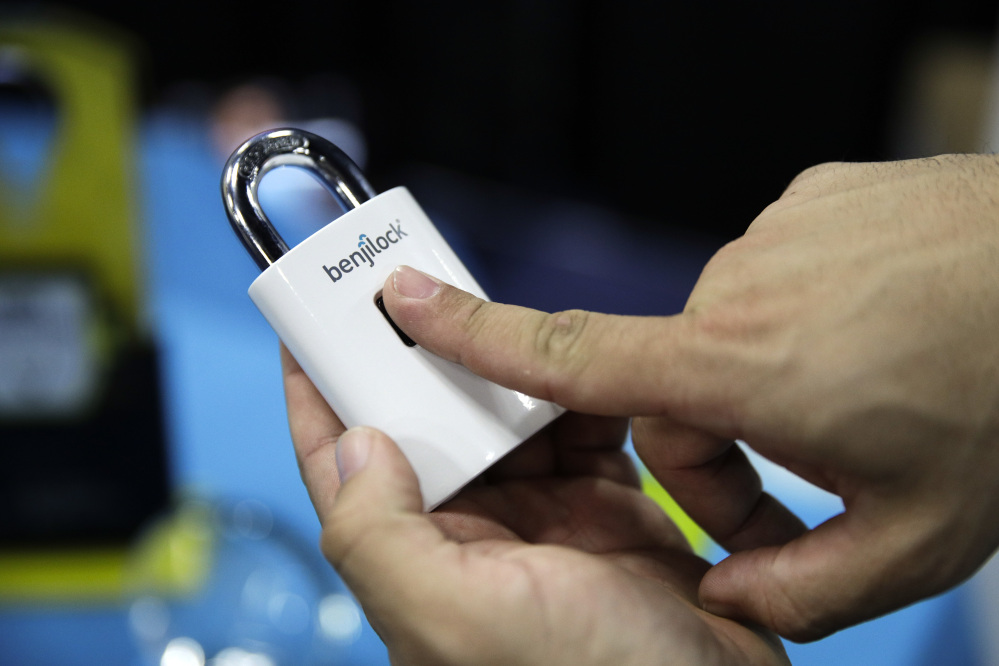 Junior Enrique demonstrates on the Benjilock, a rechargeable lock that uses fingerprint technology, during CES Unveiled on Sunday in Las Vegas. (AP Photo/Jae C. Hong)