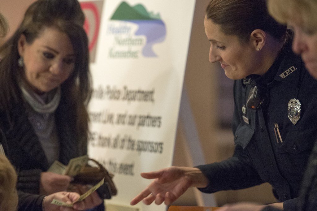 Linda Svedberg, right, a patrol officer with the Waterville Police Department, sells raffle tickets to Helen Bell-Necevski at the benefit concert.