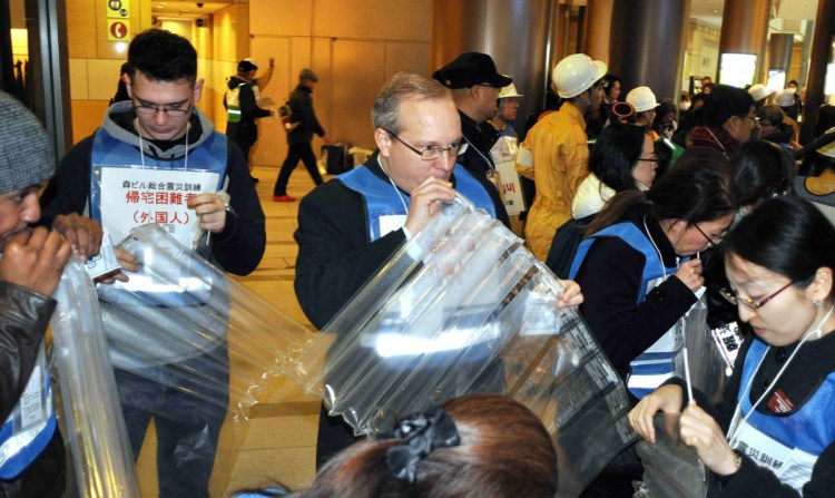 Participants inflate air mattresses during a disaster drill at Roppongi Hills in Minato Ward, Tokyo, on Wednesday. MUST CREDIT: Japan News-Yomiuri photo